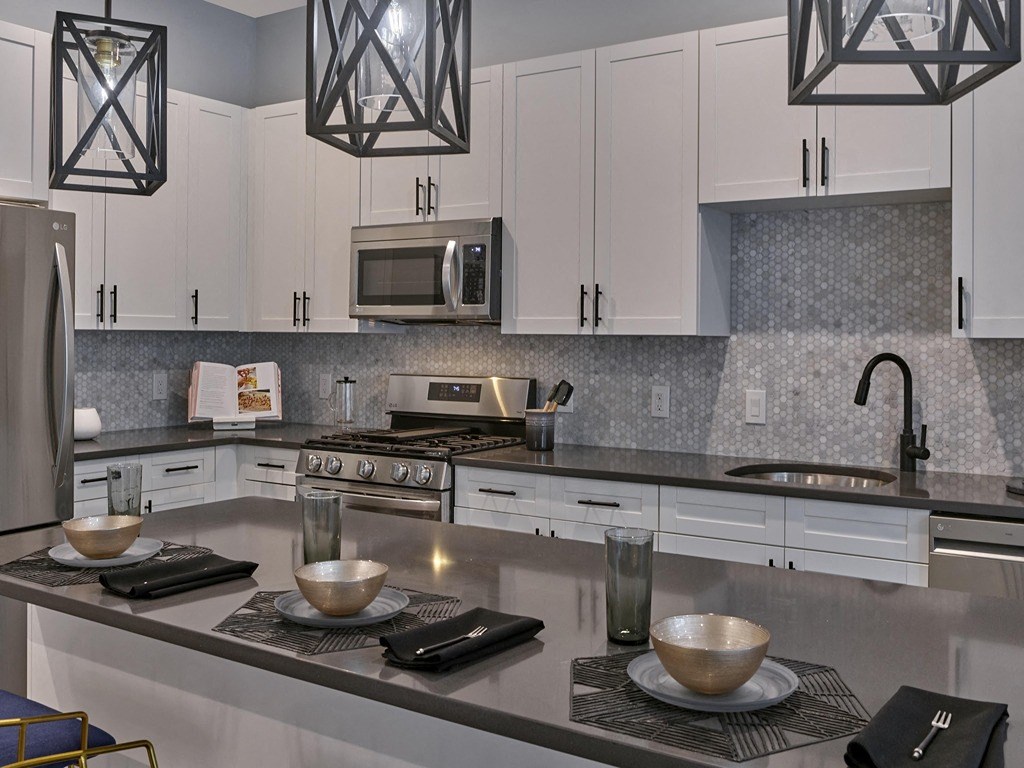 a kitchen with white cabinets and stainless steel counter tops