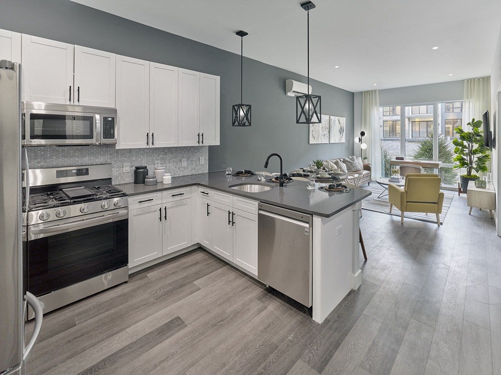 a kitchen with white cabinets and stainless steel appliances