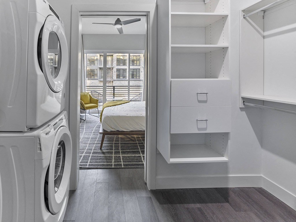 a white washer and dryer in a room with a bed