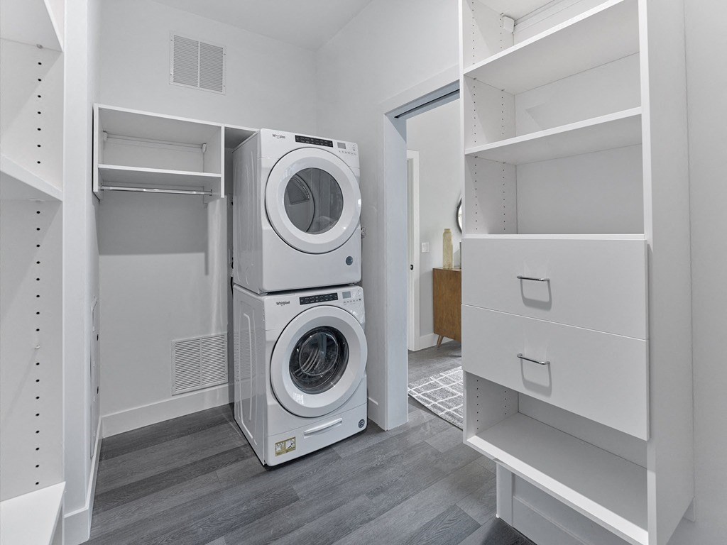 a washer and dryer in a laundry room with a white closet