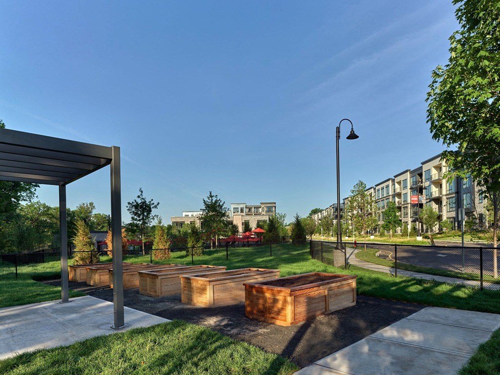 a park with benches and trees in front of a building