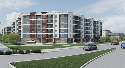 A modern apartment building with cars parked in front.