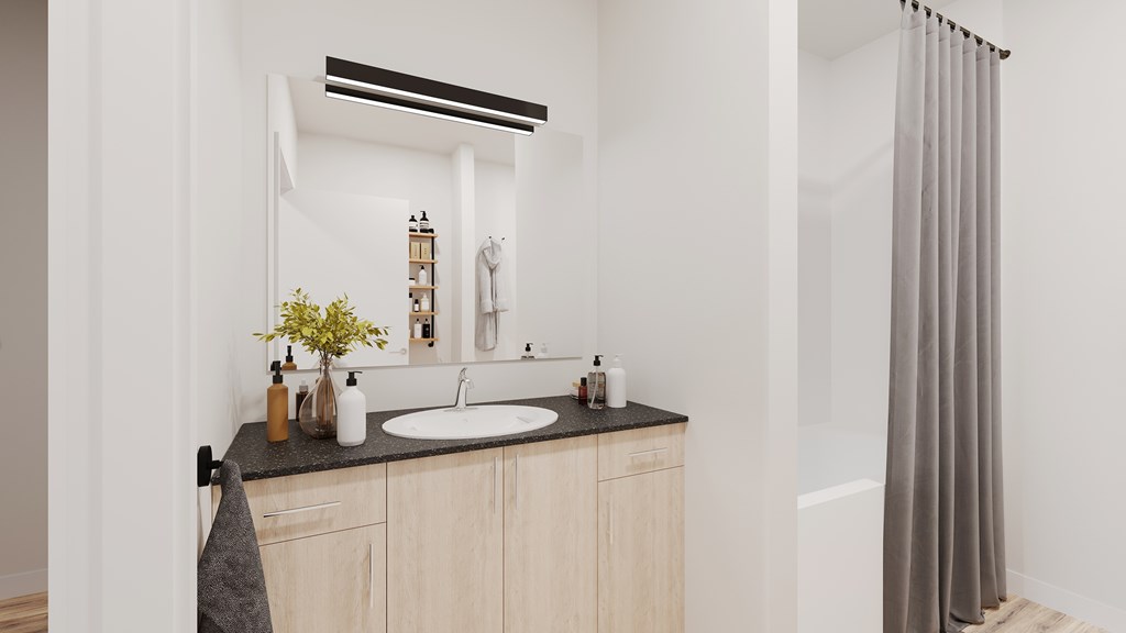A bathroom with a sink, mirror, and a grey shower curtain.