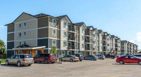 Four storey apartment building with lots of parking in front