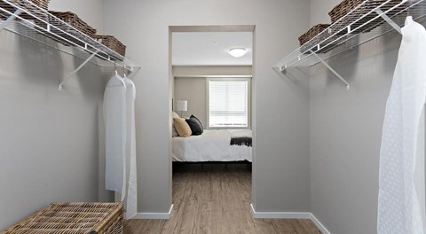 A walk in closet with wire shelving to hang clothing