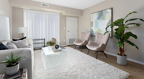 A living room with couch, coffee table and chairs with large glass sliding door