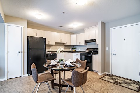 A kitchen with a table and chairs in the middle.