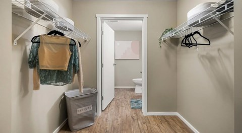 A walk in closet with wire shelves on either side for hanging clothes. A door leading to an ensuite on the end