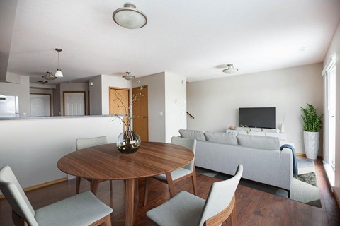 A modern living room with a grey couch and a wooden table.
