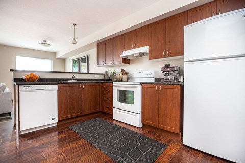 A kitchen with wooden cabinets and white appliances.