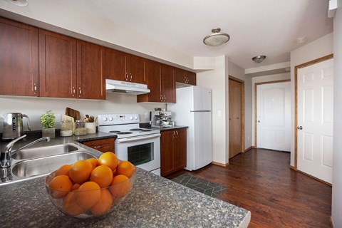 A kitchen with a bowl of oranges on the counter.
