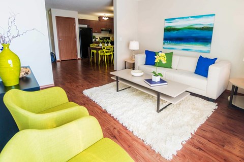 A living room with a white couch and yellow chairs.