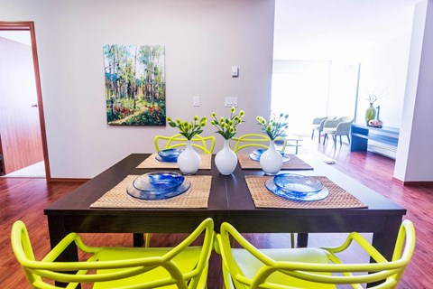 A dining table with two yellow chairs and a blue plate on it.