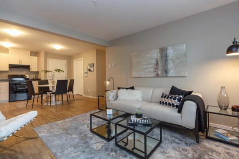 A modern living room with a white sofa and a glass coffee table.