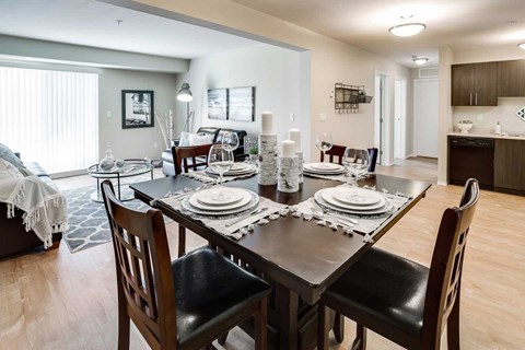A dining room with a table set for a meal.