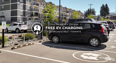 A parking lot with a sign offering free EV charging for brook street tenants.