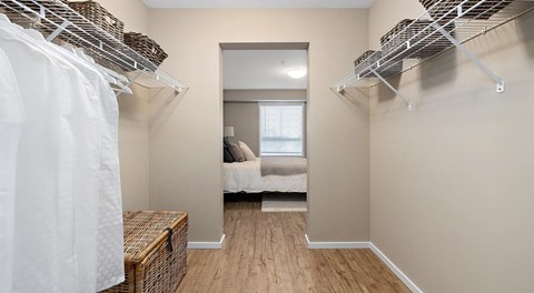 A walk in closet with shelving on either side