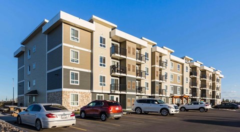A four storey apartment building with parking in front