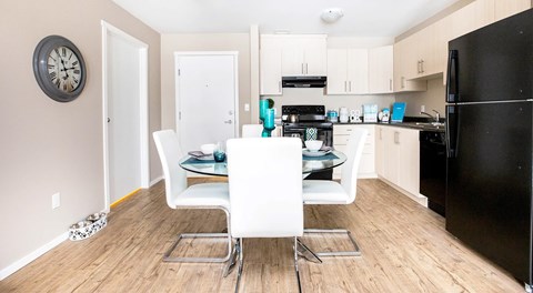 A kitchen with light cabinets and black appliances