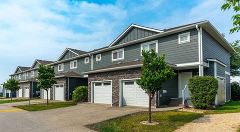 A row of townhomes with single car garage and driveway