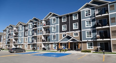 A large apartment building with balconies and parking