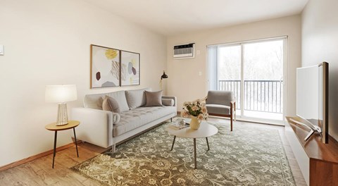 A living room with a couch, chair and coffee table with a large glass sliding door