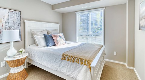 A bedroom with a large bed and a window.