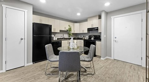 open kitchen with black appliances and a round table set for four