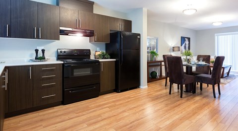 A modern kitchen with dark wood cabinets and a black appliances