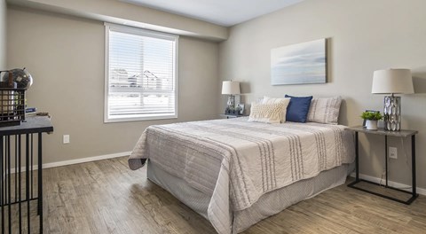 A bedroom with a large bed and a painting on the wall.