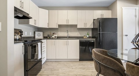 bright open kitchen with light cabinetry and black appliances