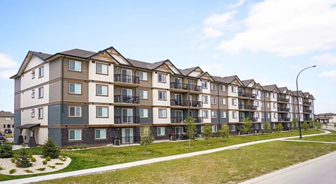 A row of modern apartment buildings with balconies and multiple stories.