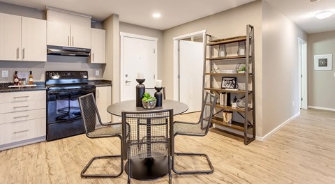 a modern open kitchen with dining table, front entrance and laundry room entrance