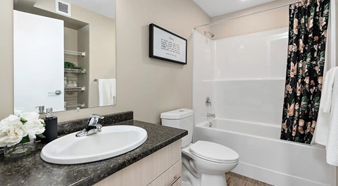 A bathroom with a white toilet, sink, and bathtub.