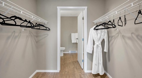 A walk through closet leading to a bathroom