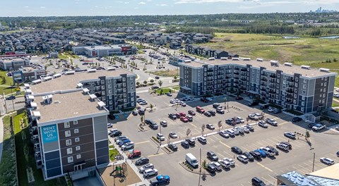 A large apartment complex with a large parking lot in the centre