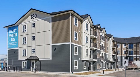 A four storey apartment building with parking in front