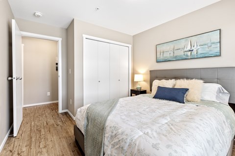 A bedroom with a large bed and a painting on the wall.