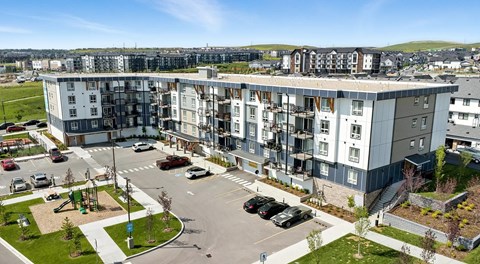 A large apartment building with a parking lot in front of it.