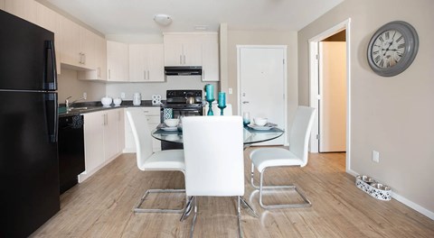 A kitchen with light cabinets and black appliances