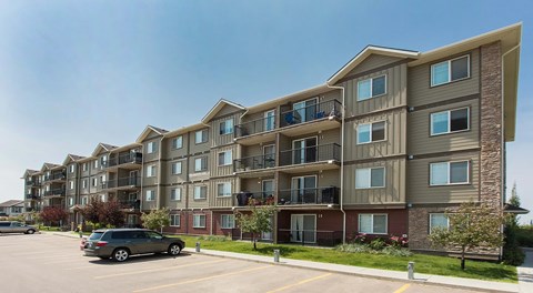 A large apartment building with parking in front