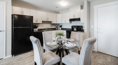 A kitchen with light cabinets and black appliances
