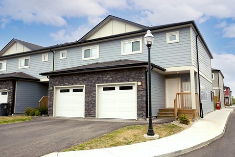 A two-story house with a garage and a driveway.