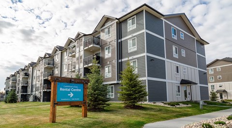 A large apartment building, with green grass out front