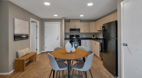 A kitchen with a table and chairs in the middle of the room.