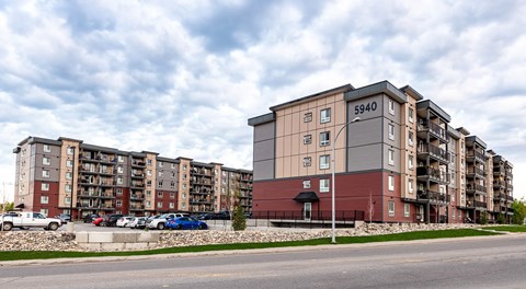 large apartment complex, with lots of parking between the buildings