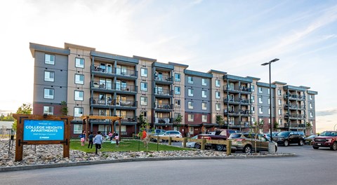 A large modern apartment building with lots of parking out front