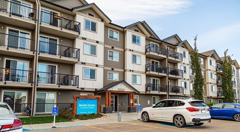A apartment building with cars parked in front