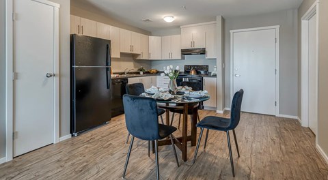 A kitchen with a dining table and chairs.