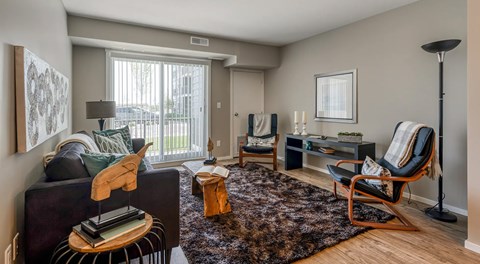 A living room with a couch and chairs, large glass sliding door